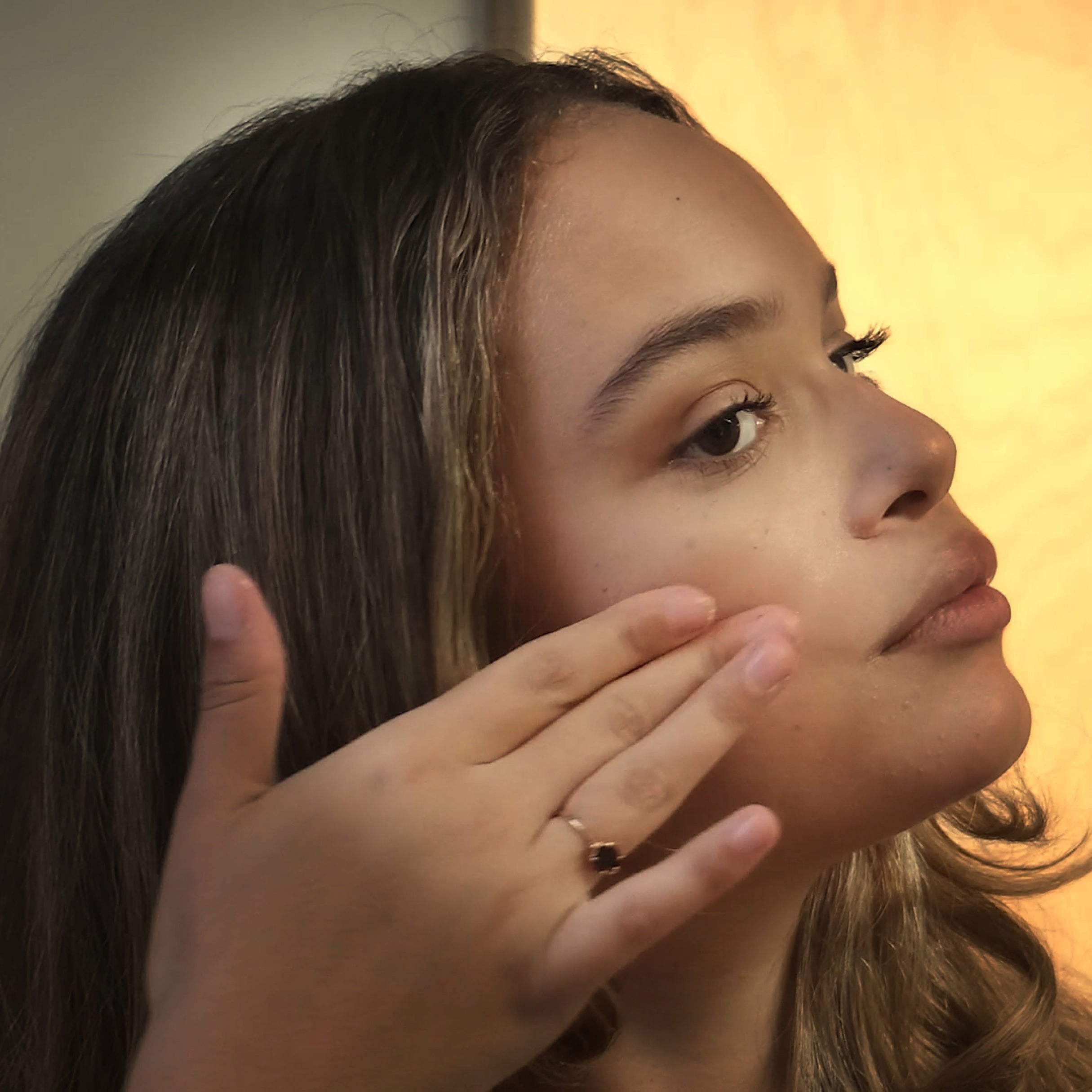 Touching face to show hydration and softness after using WORLD products.